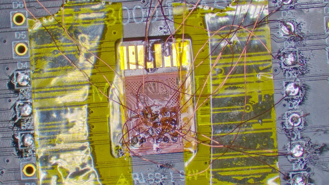 Micro-jumper wires rebuilding damaged copper pads and traces directly on a chip under a microscope in the MDrepairs lab