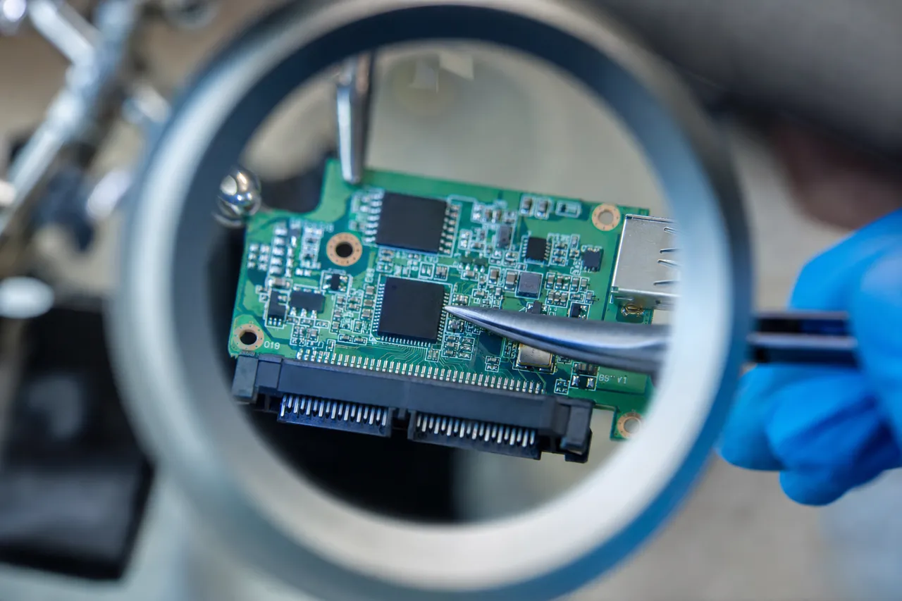 A hard drive printed circuit board removed from the drive on the bench, showing the controller chip, motor driver and ROM chip during board-level diagnosis